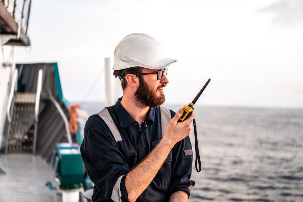 Company Security Officer on a ship, talking on a radio. 