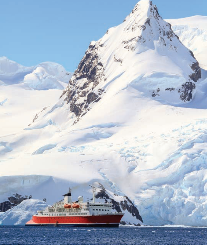 Image of a ship in Polar water, with white snowy mountains in the background | Polar Code