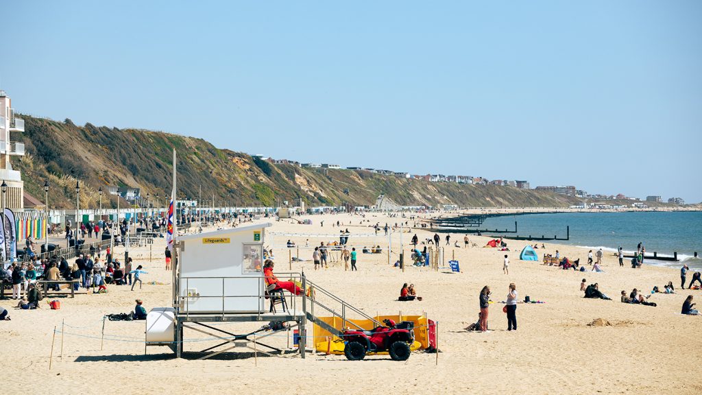 Lifeguard enforcing drowning prevention on a busy beach