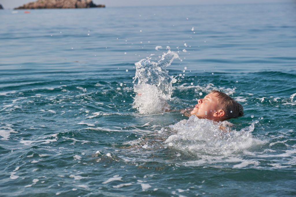 Boy starting to drown at sea