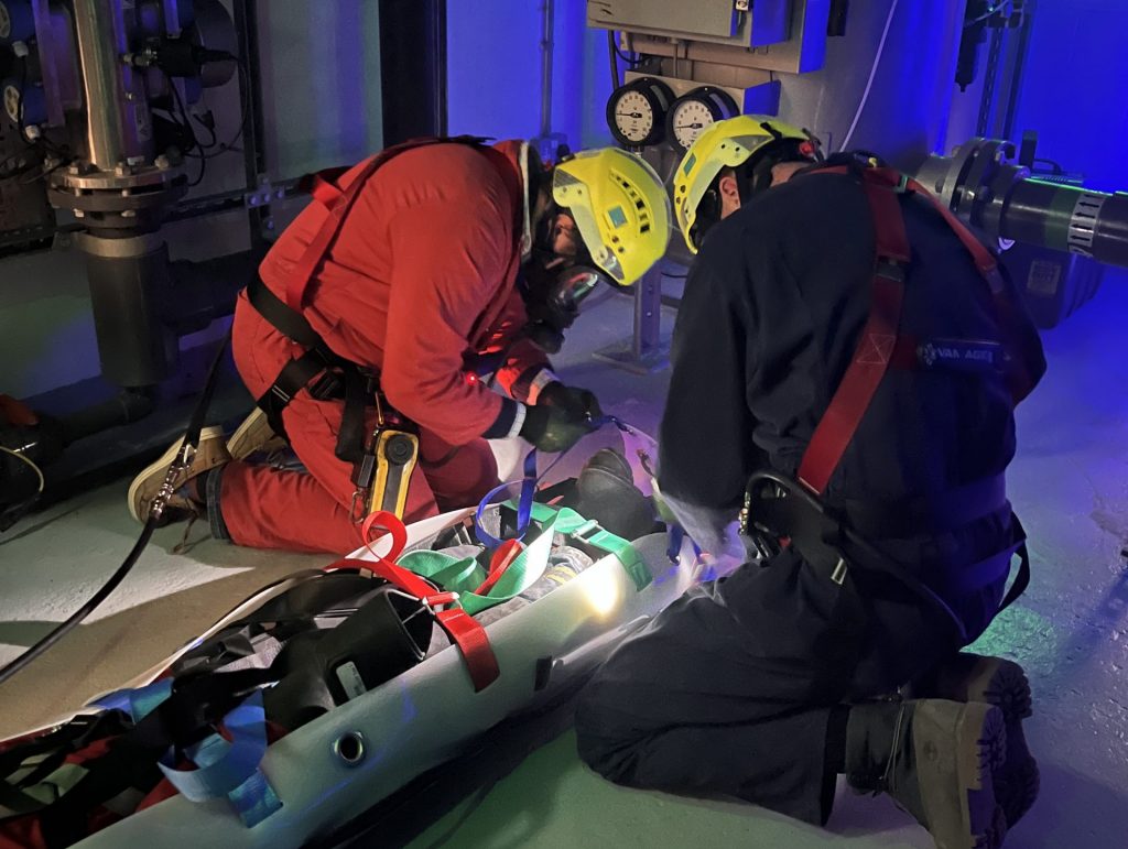 Two delegates aiding a simulated casualty in an enclosed space at MSA