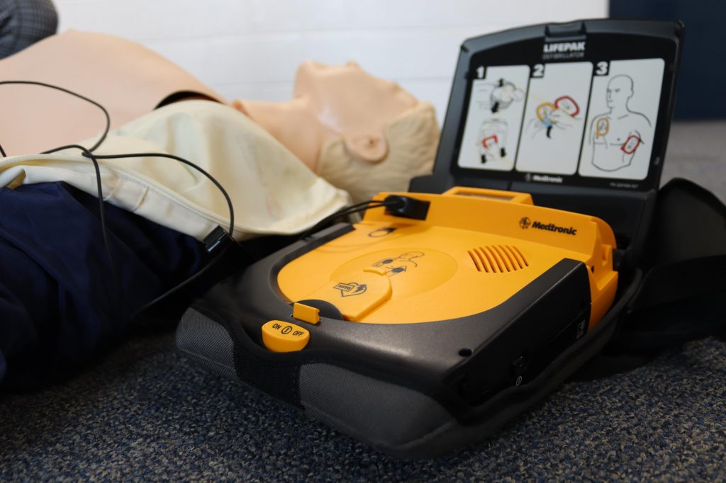 image of an AED and manikin doll on the floor