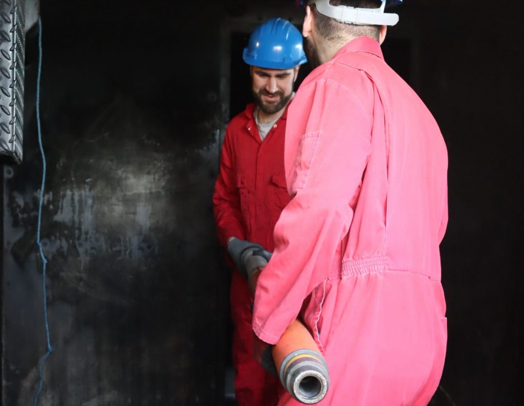 Two maritime delegates holding paratech during damage control training