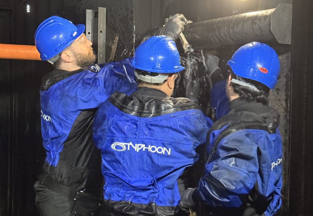 Three damage control training delegates fixing a leak