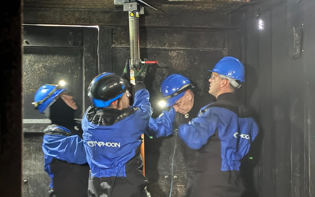 Four damage control delegates fitting paratech in a container during their final exercise